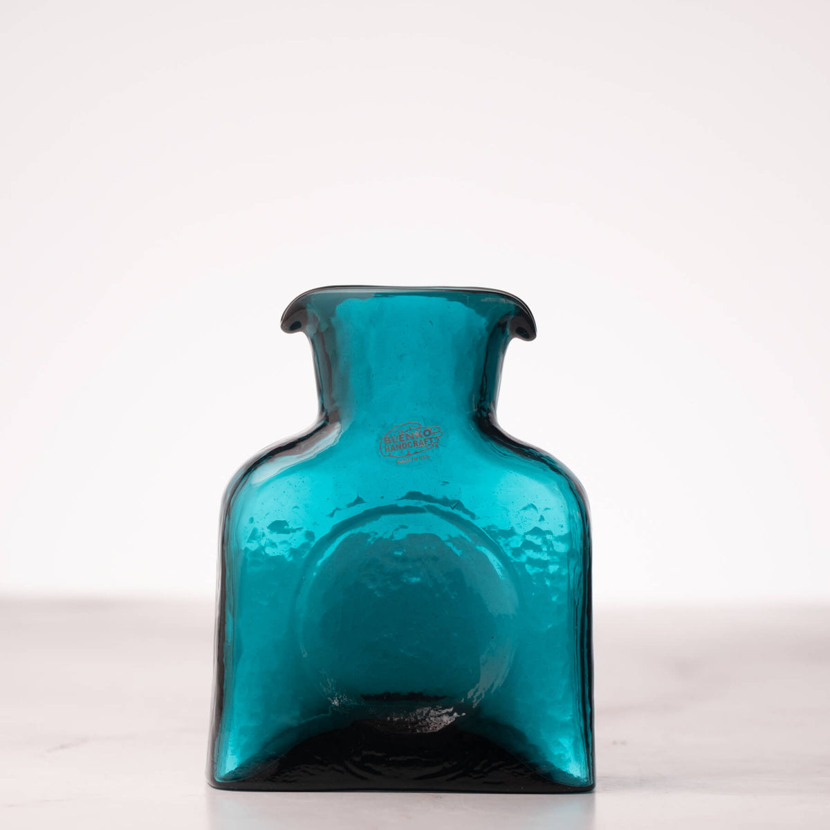 Teal glass bottle on a white background