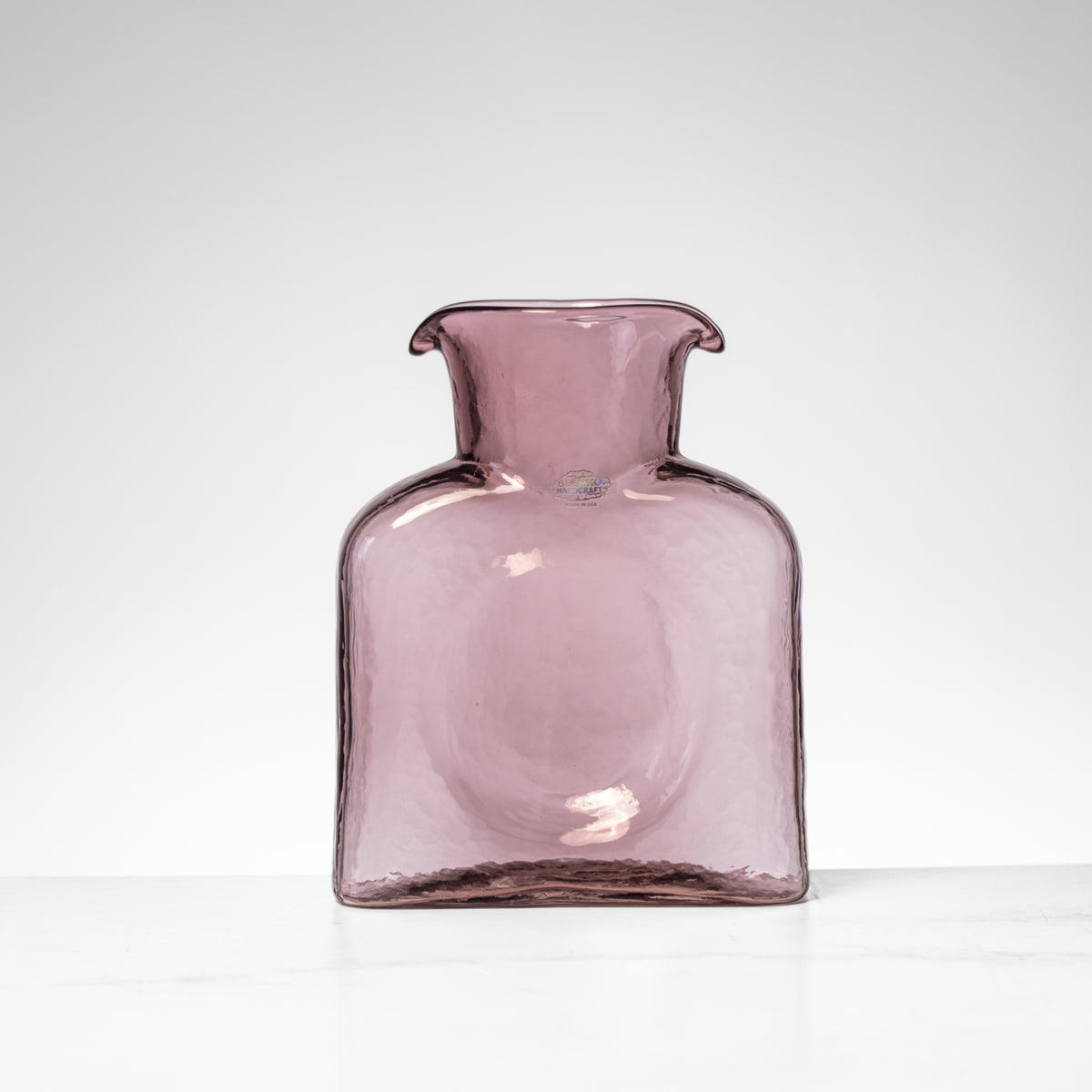 Pink glass vase on a white background
