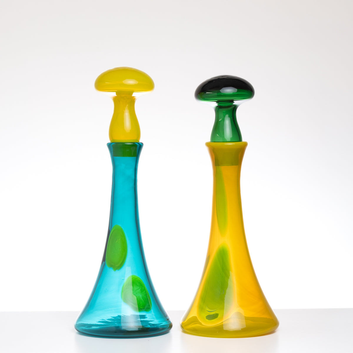 Two colorful glass bottles with unique designs on a white background