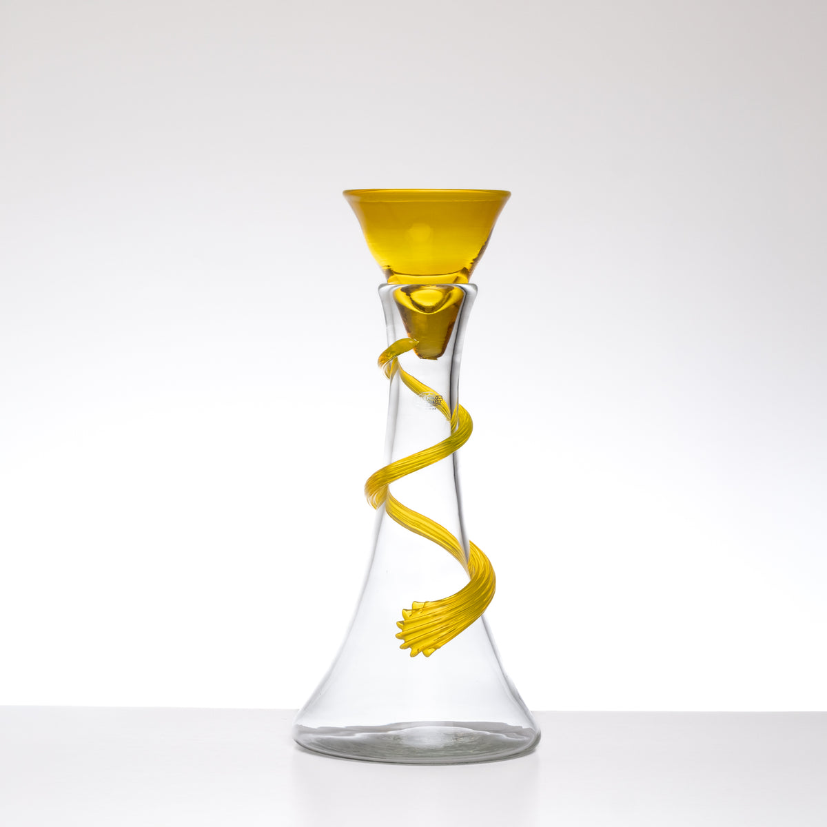 Clear glass carafe with yellow螺旋设计 on a white background