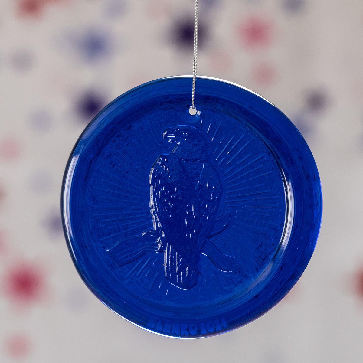 blue circular ornament with textured surface on a blurred background
