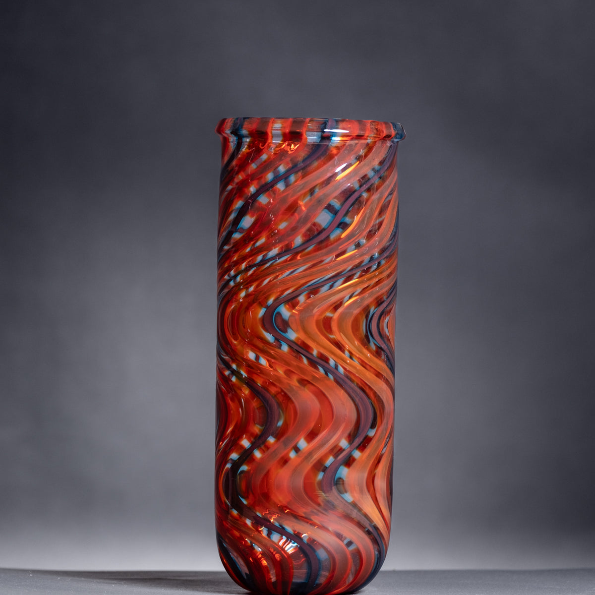 Decorative glass vase with wavy pattern on a gray background