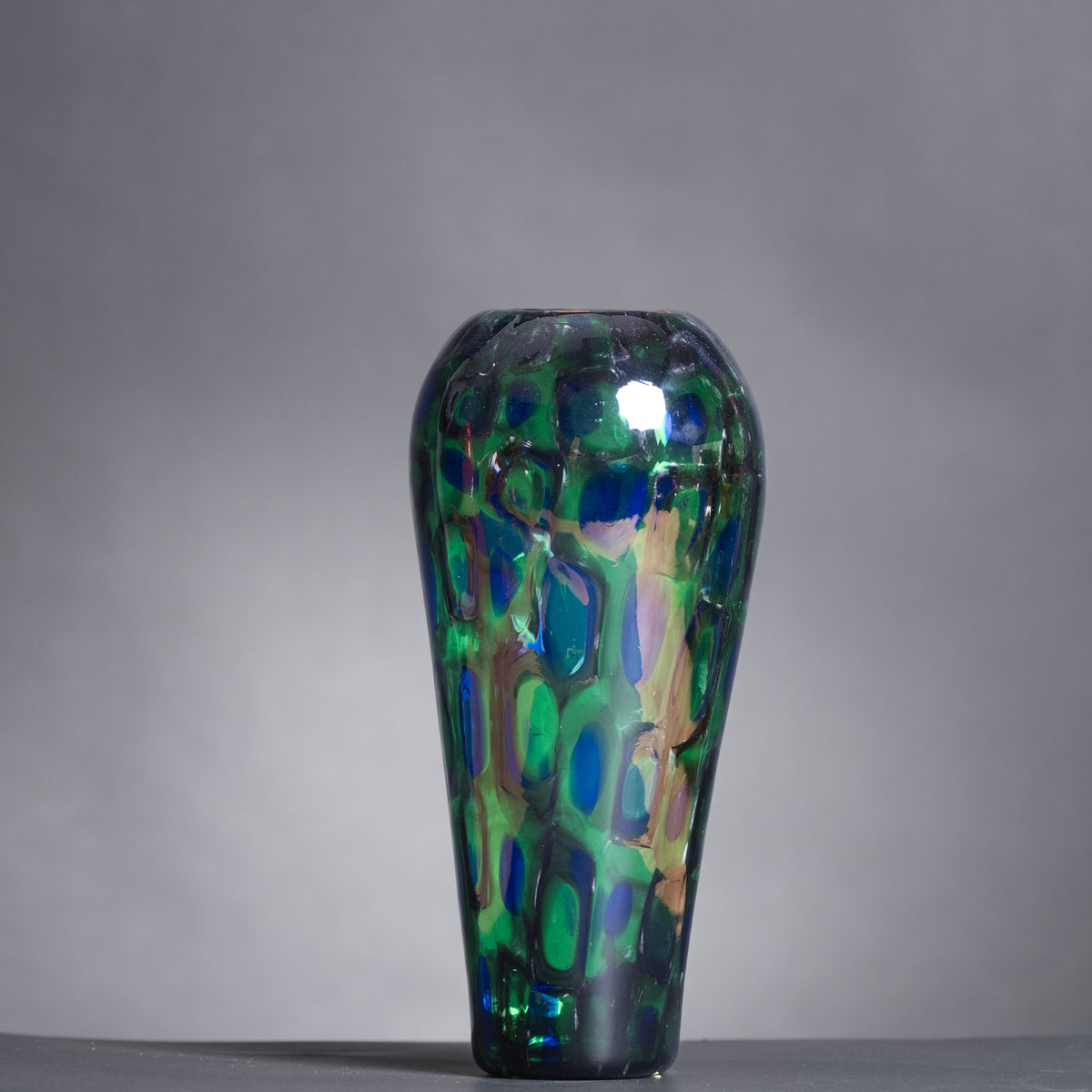 Decorative glass vase with a colorful pattern on a gray background