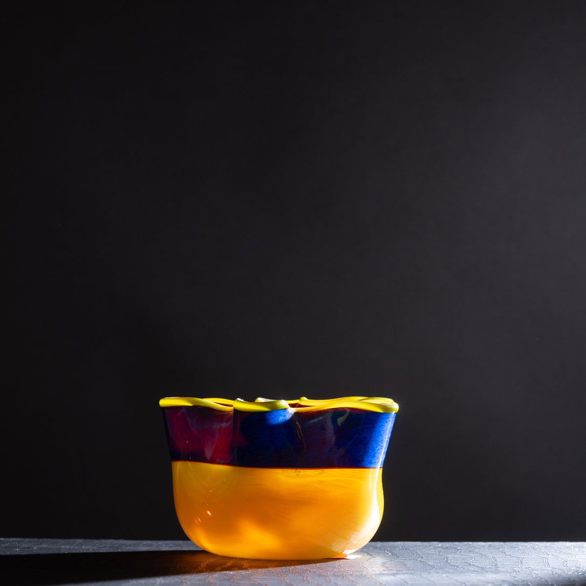 Colorful glass bowl on a dark background