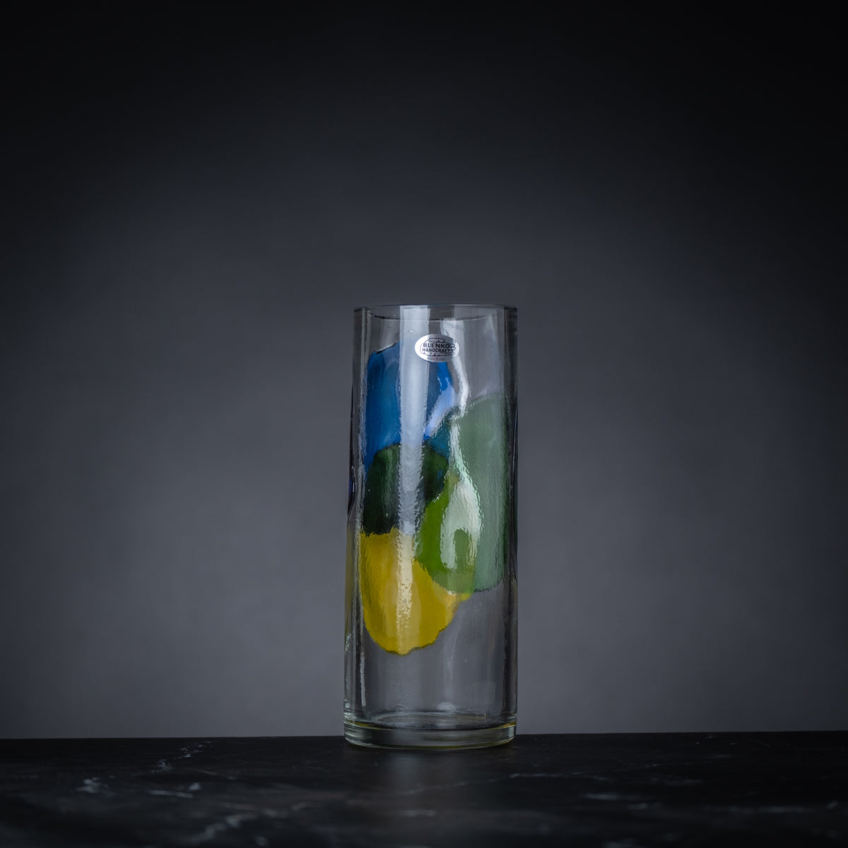Clear glass vase with colorful design on a dark background