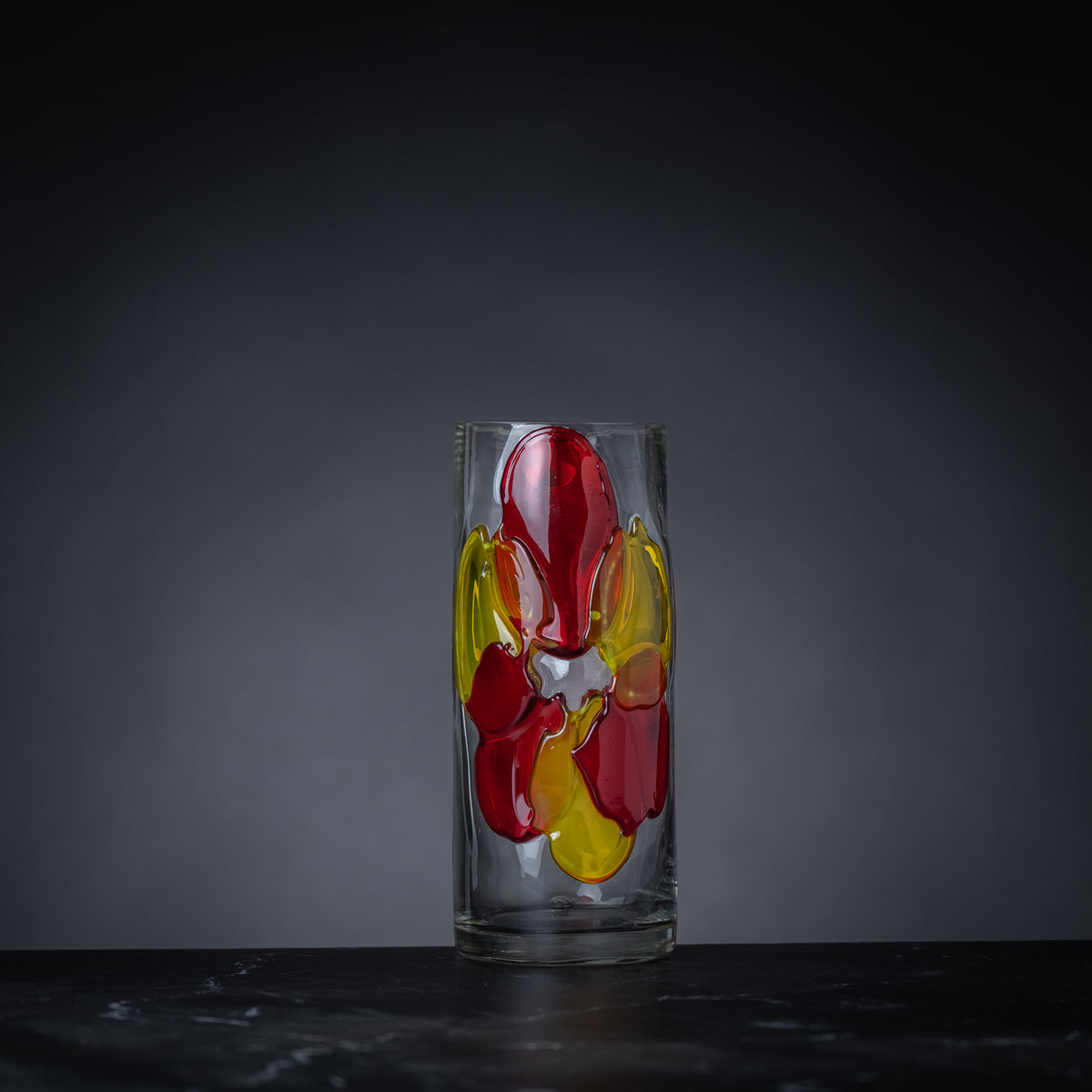 Glass with colorful design on a dark background