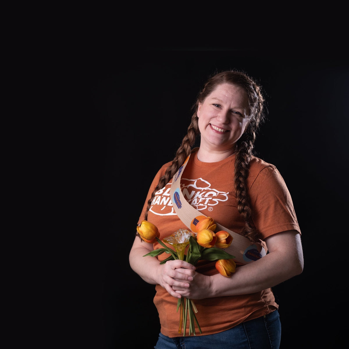 Woman with flowers and orange shirt on a black background