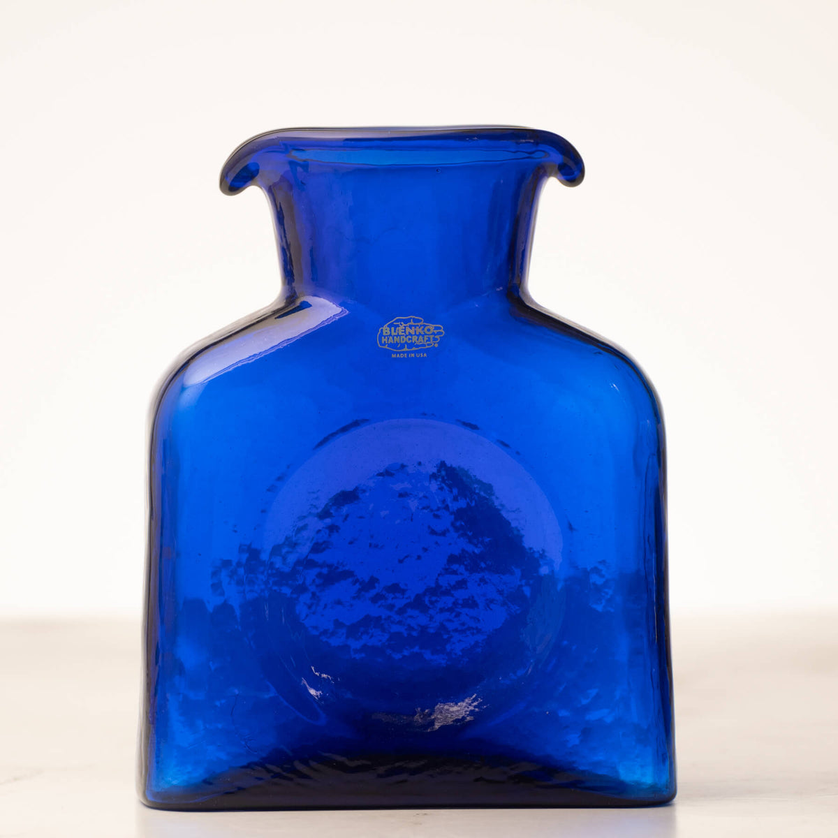 Blue glass vase with 'Anchor Hocking' branding on a white background