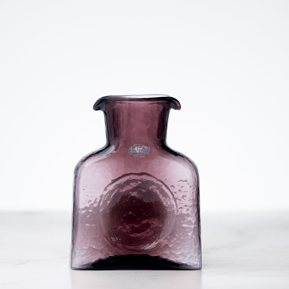 Purple glass vase on a white background