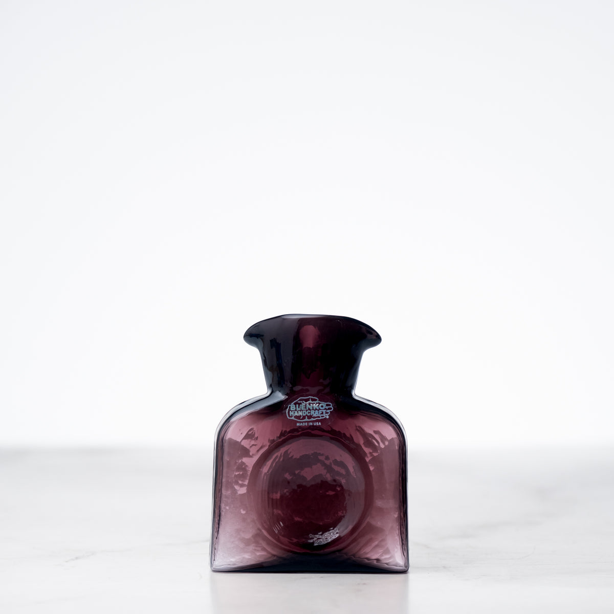 Amethyst-colored bottle with a label on a white background