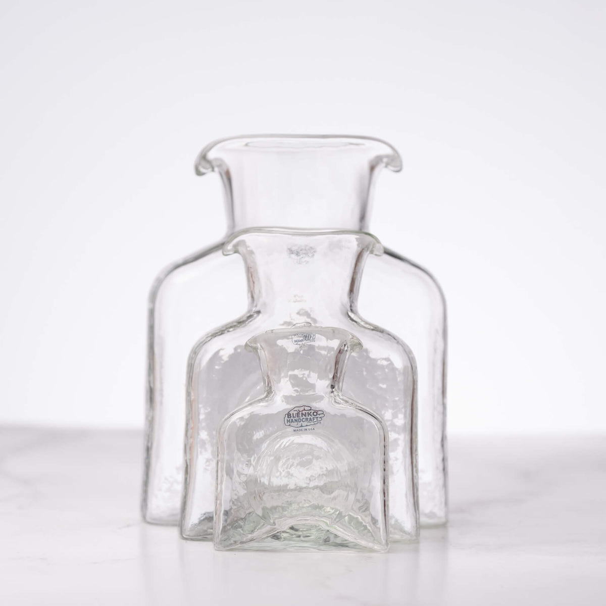 Clear glass bottle with visible branding on a white background