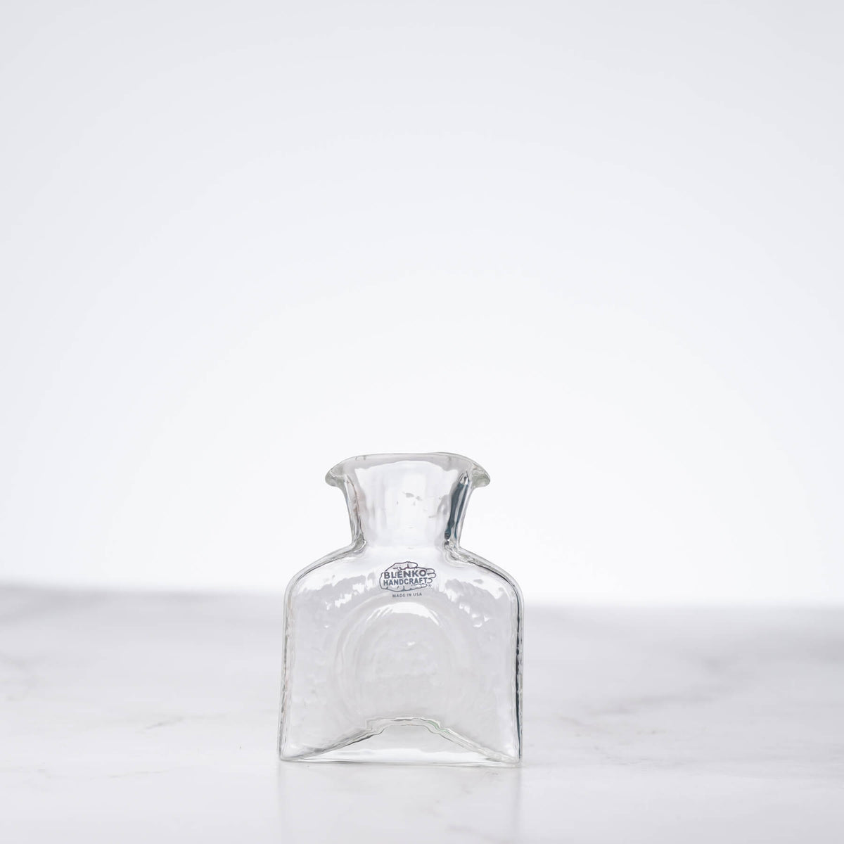 Clear glass carafe on a white background