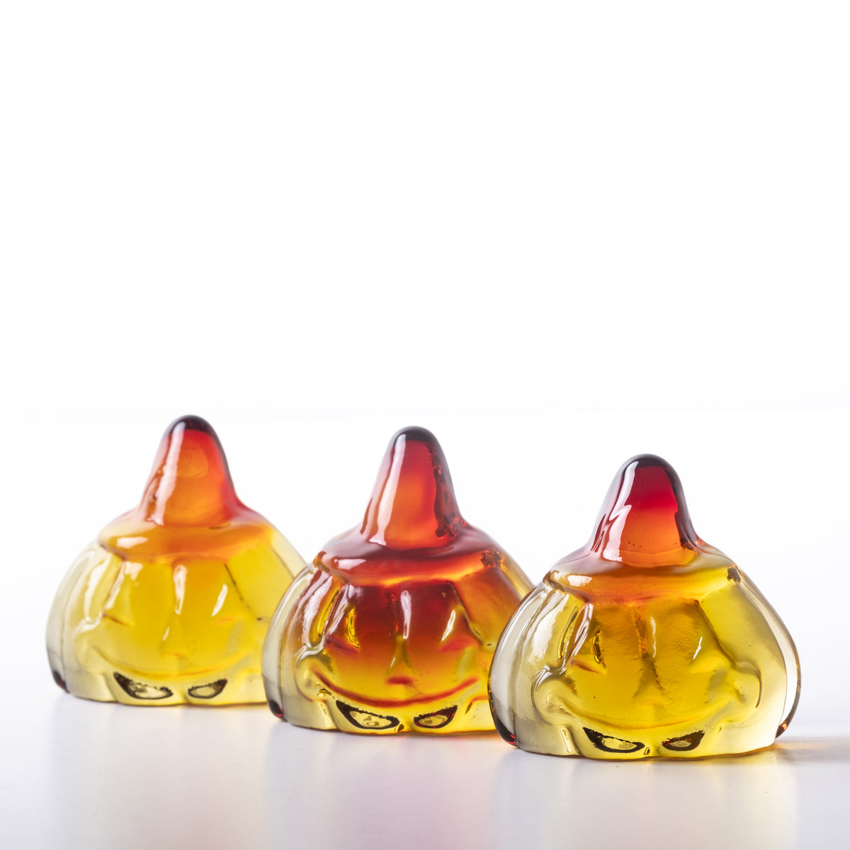 Glass pumpkin figurine with a smiling face on a white background