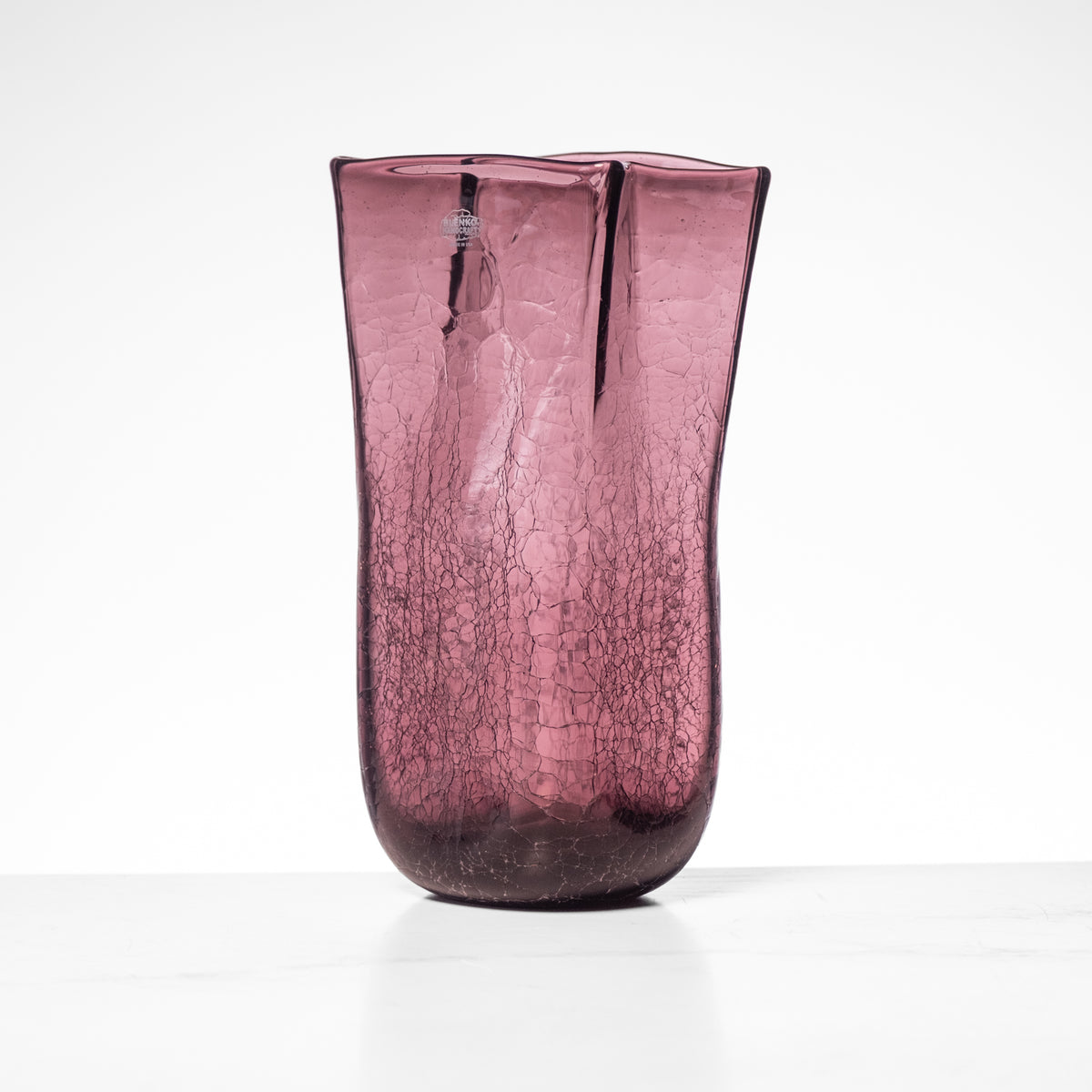 Purple cracked glass vase on a white background