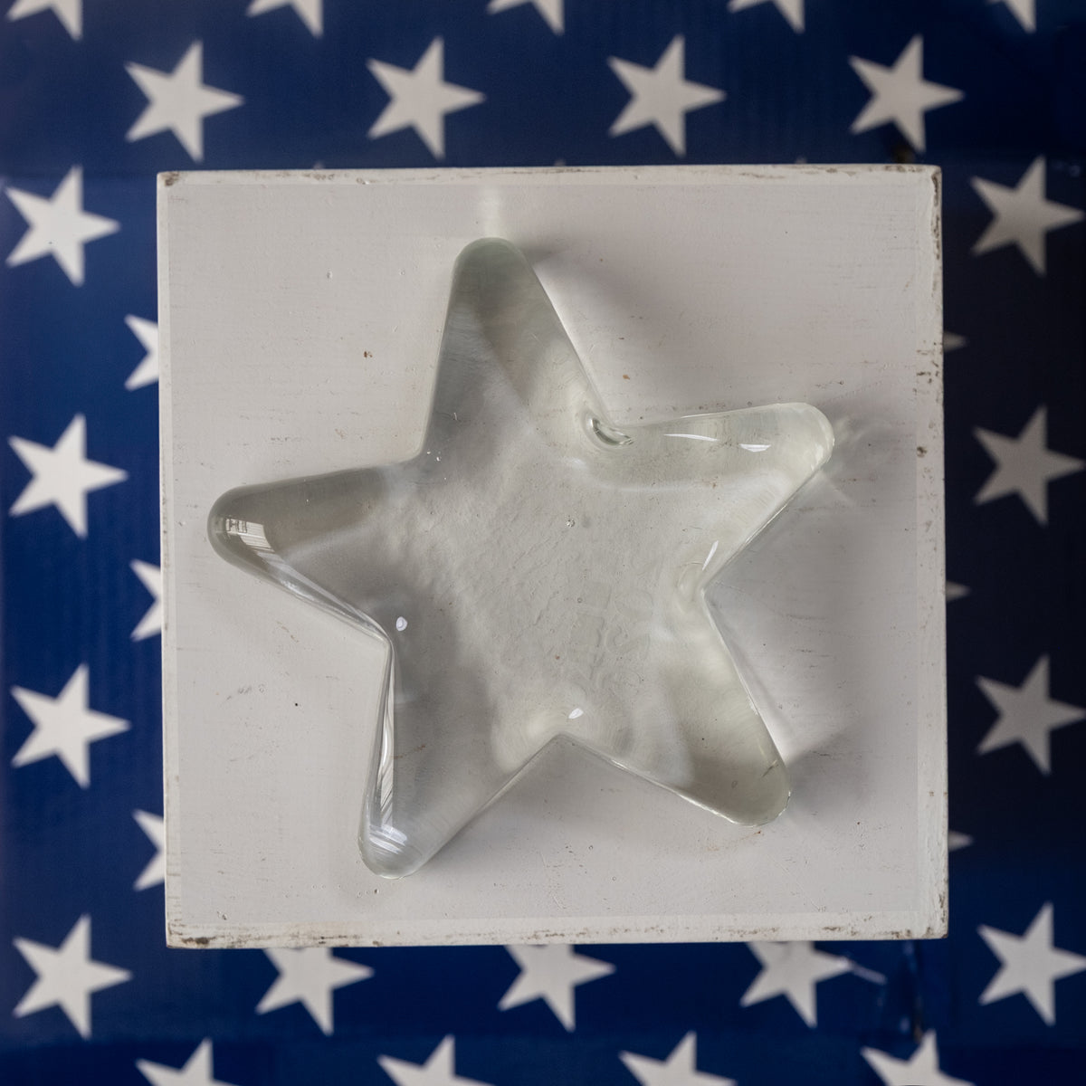 Metal star-shaped cookie cutter in a white box with an American flag background