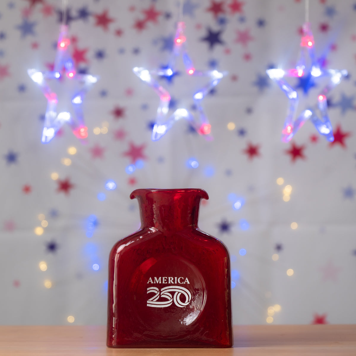 Red bottle labeled 'America 250' with festive lights and stars in the background
