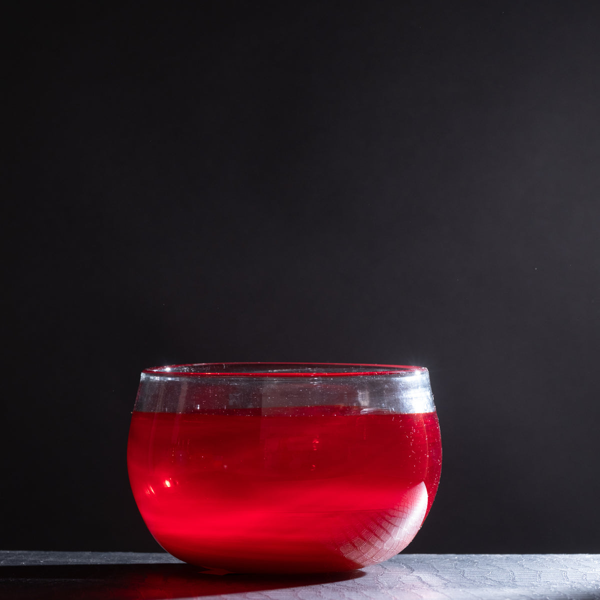 Red glass bowl on a dark background