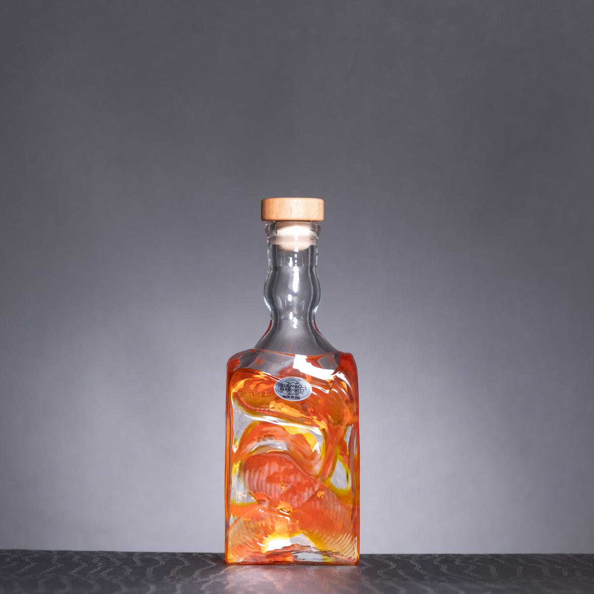 Glass bottle with a cork stopper on a gray background