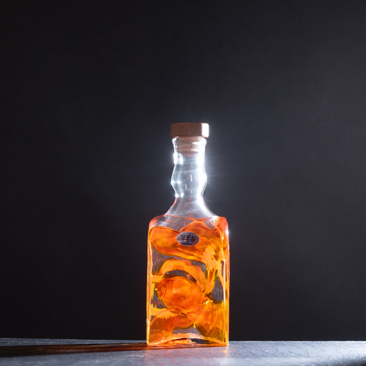 Glass bottle with amber liquid on a dark background
