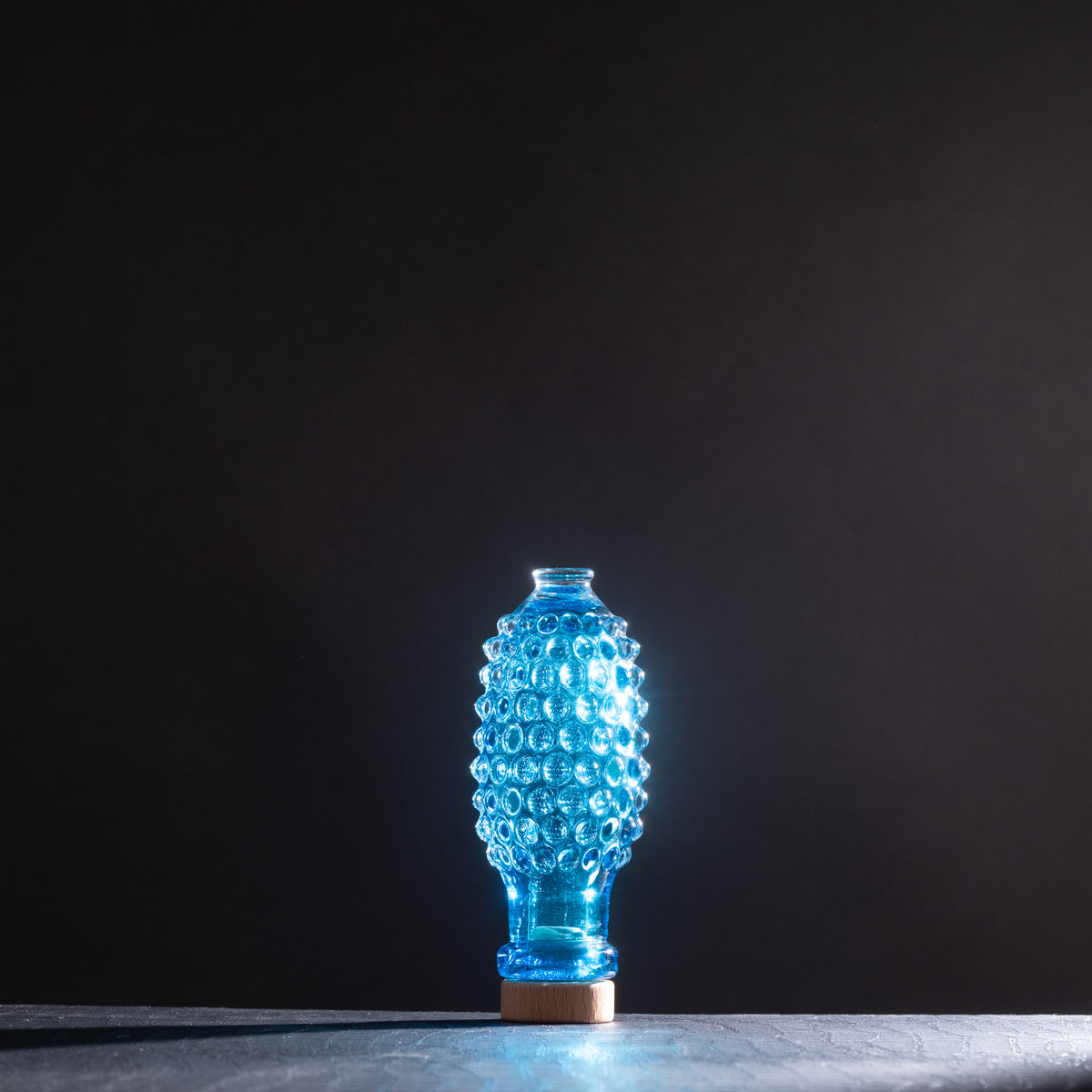 Blue textured vase on a dark background
