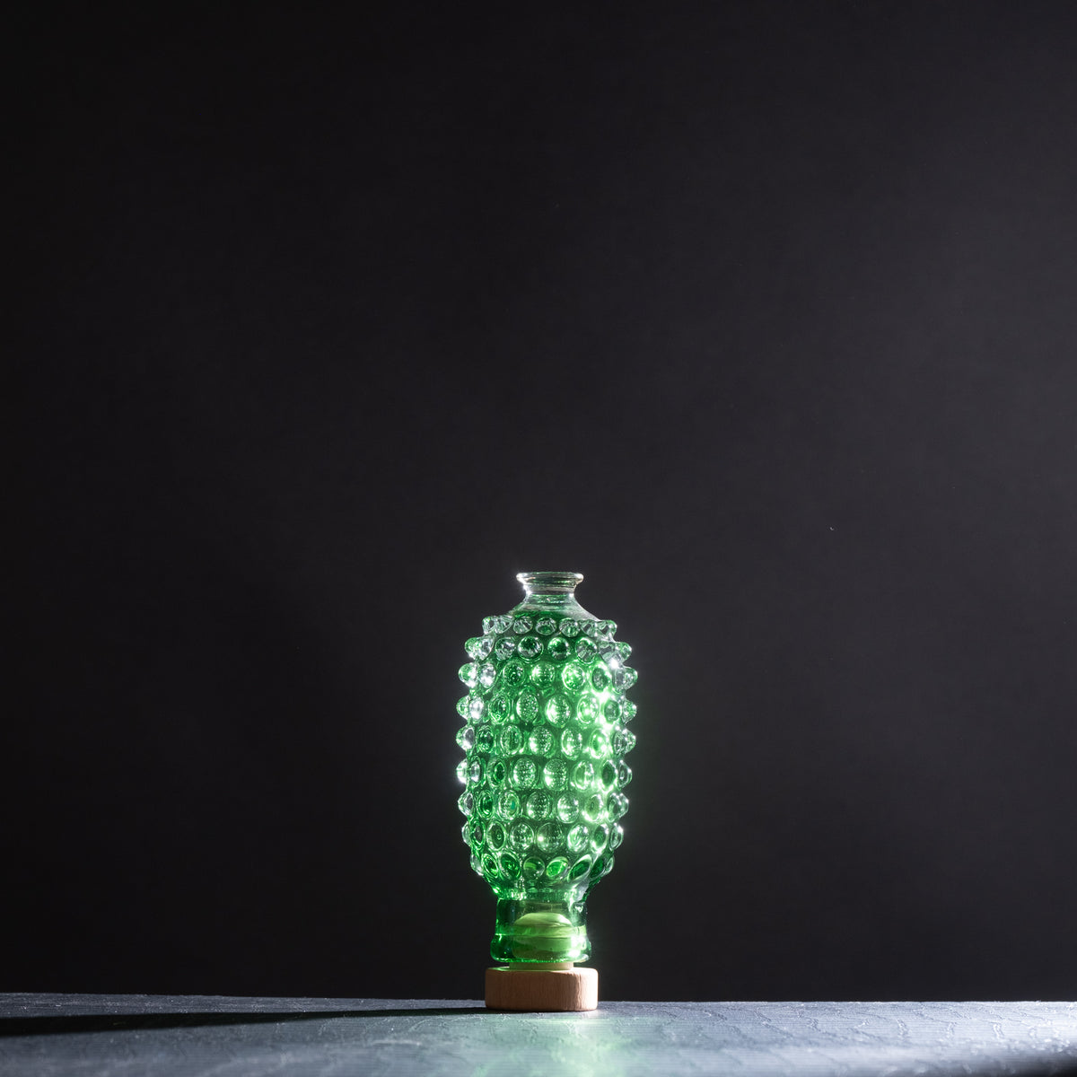 Green textured vase on a dark background