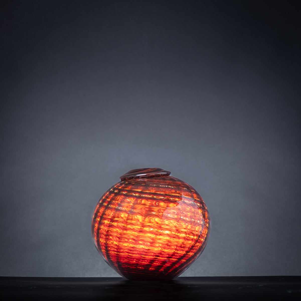 Decorative glass vase with a textured surface on a dark background