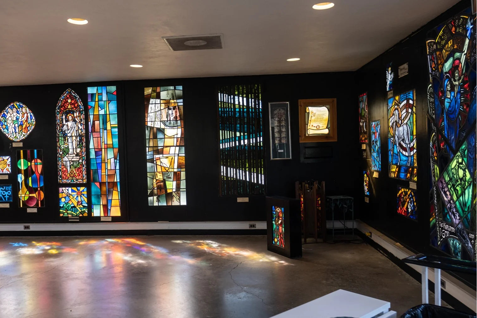 Stained glass windows in a room with black walls